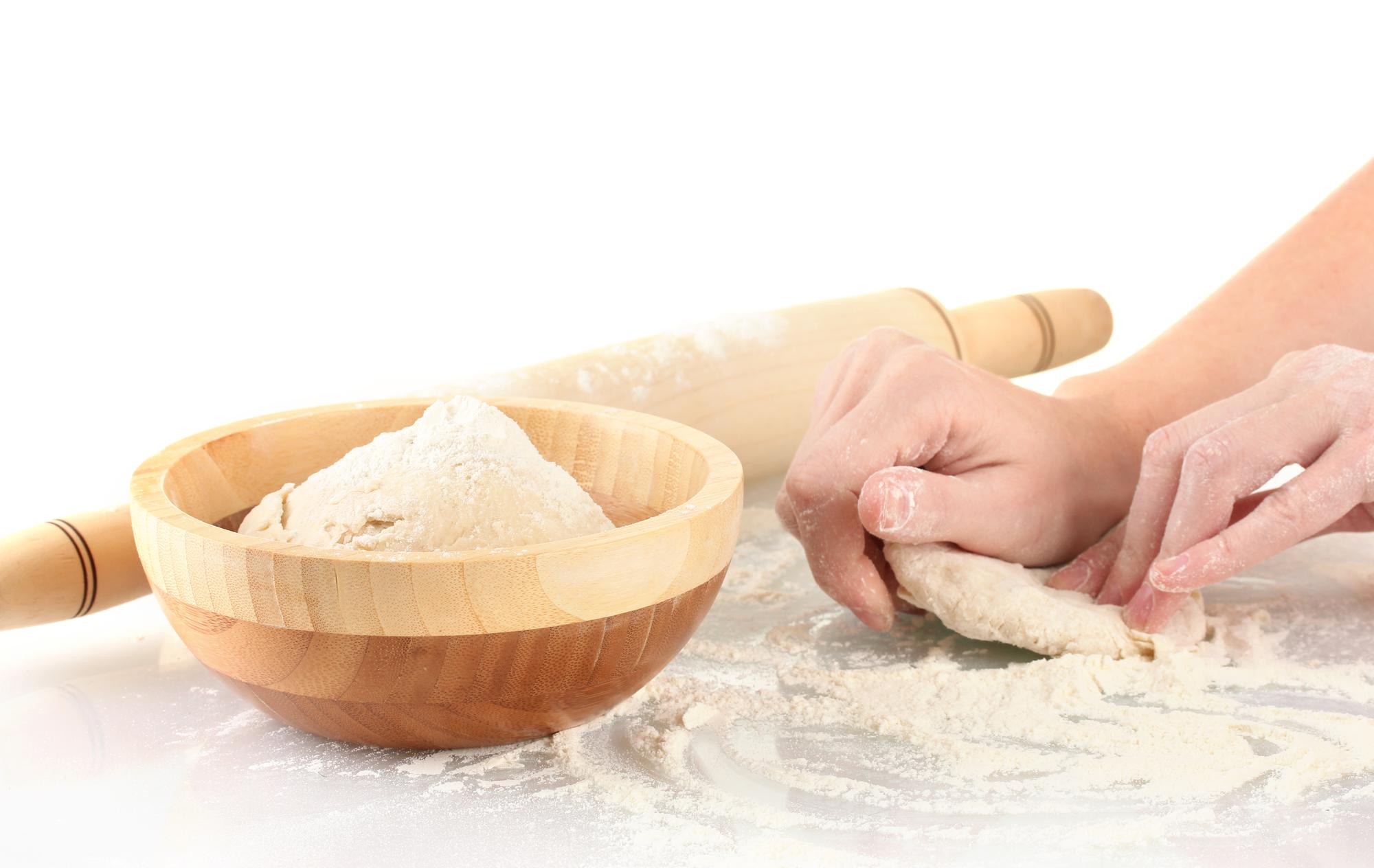 Dettaglio di una lezione pratica con mani che impastano