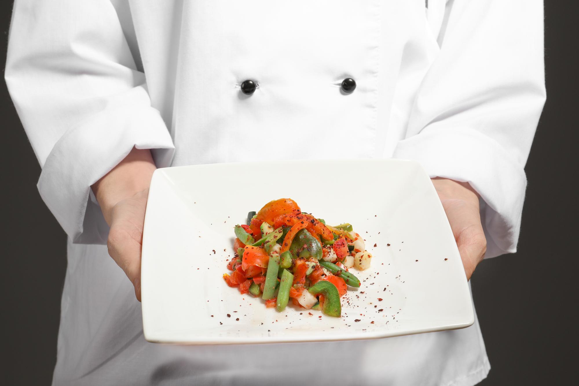 Chef che prepara un piatto locale in cucina moderna
